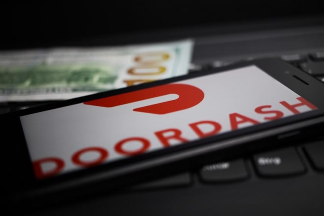 Close up of mobile phone screen with logo lettering of Doordash payment provider on computer keyboard