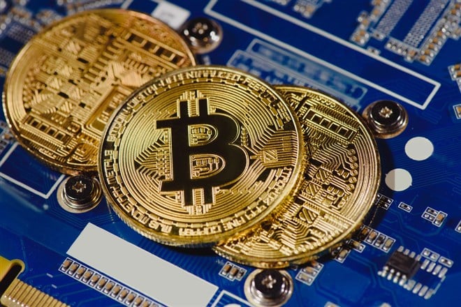 Close up view of arranged golden bitcoins on computer motherboard — Stock Editorial Photography