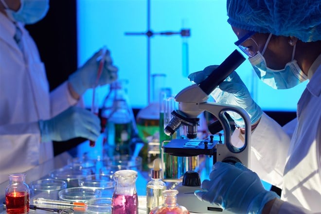 Scientist doctors working in laboratory and using microscope — Photo