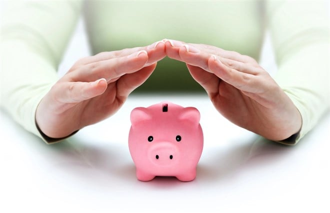 Photo of a pink piggy bank with someone holding hands above it symbolizing protecting your wealth