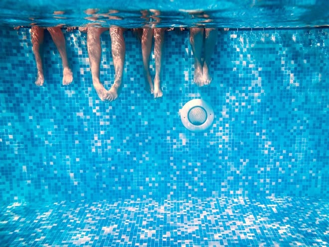 Children's and adults legs underwater — Photo