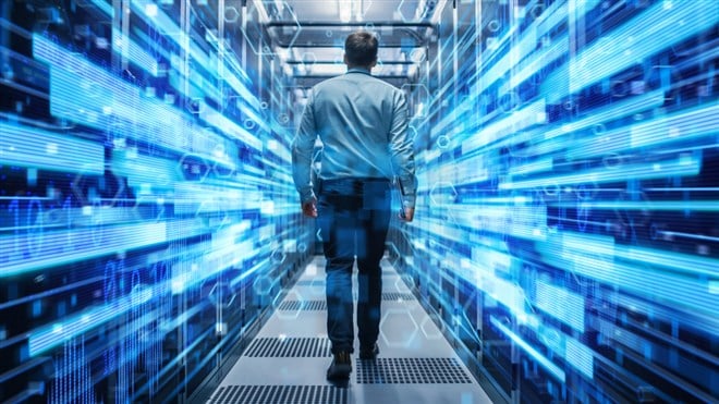 Shot of a Young It Specialist Walking through Corridor in Working Data Center Full of Rack Servers and Supercomputers. Conceptual Visualisation of High Speed Internet Connection with Digits and Lines. — Photo