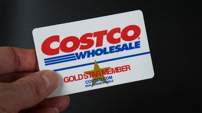 Costco Gold Star Membership card held against a black background. — Stock Editorial Photography