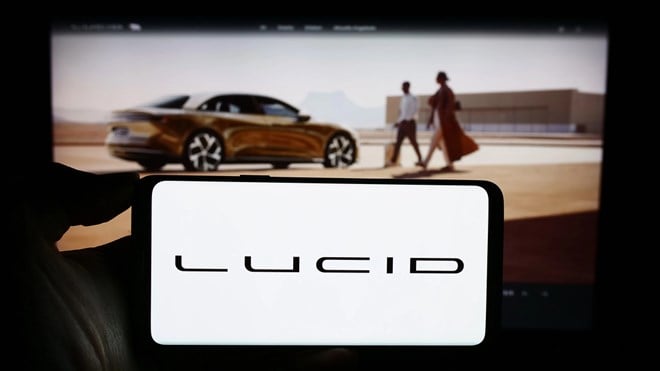 Stuttgart, Germany - 11-17-2023: Person holding smartphone with logo of US electric luxury vehicle company Lucid Motors in front of website. Focus on phone display. — Stock Editorial Photography