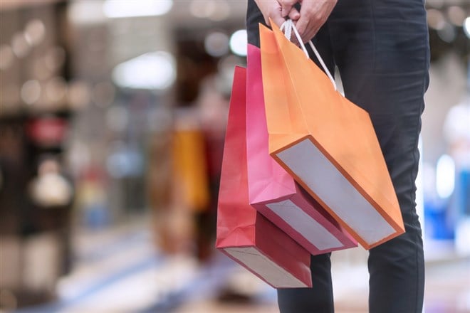 Hand of woman carrying shopping bags on shopping malls background. happiness, consumerism, sale and people concept. — Photo