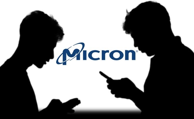 Photo of two silhouetted people on their smartphones with the Micron logo between them. 