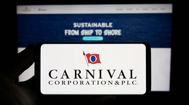 Stuttgart, Germany - 06-25-2023: Person holding smartphone with logo of cruise company Carnival Corporation plc on screen in front of website. Focus on phone display. — Stock Editorial Photography