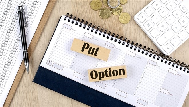 PUT OPTION word written on wooden block on planner with coins, clipboard and calculator