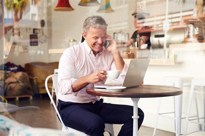 Business man working with laptop and phone from coffee shop