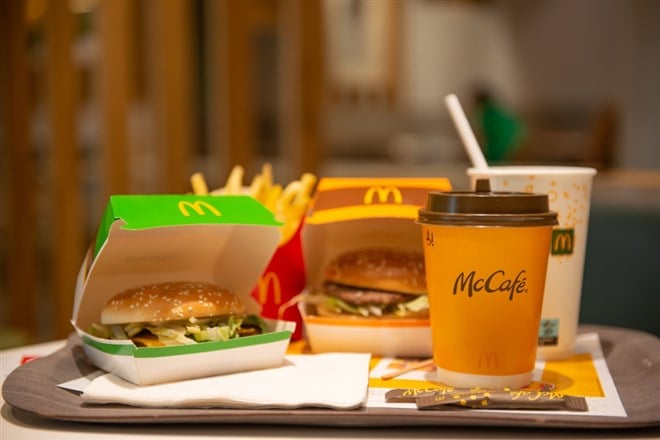 WARSAW, POLAND - SEPTEMBER 04, 2022: McDonald's French fries, burgers and drinks on table indoors - stock image