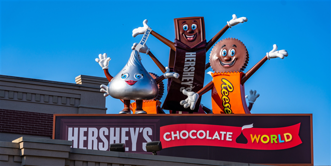 Hershey, PA, USA - December 11, 2018: Hershey Candy Characters waving from a roof at the entrance to Chocolate World. — Illustration