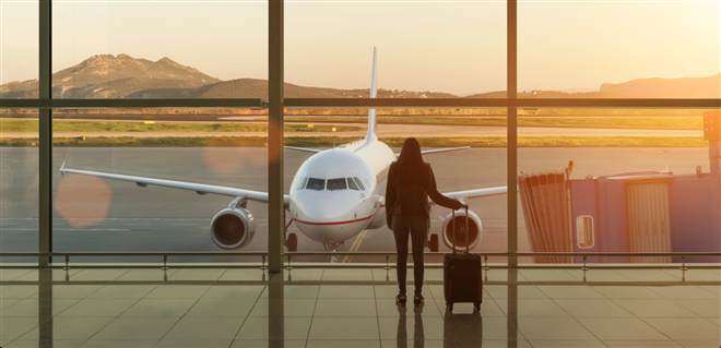 Young woman with suitcase in the departure hall at airport. Travel concept. — Photo