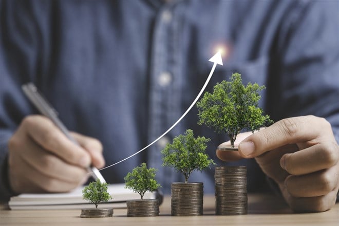 Businessman holding trees growing on increasing coins stacking for money saving and deposit growth from investment profit , Financial banking concept. — Photo