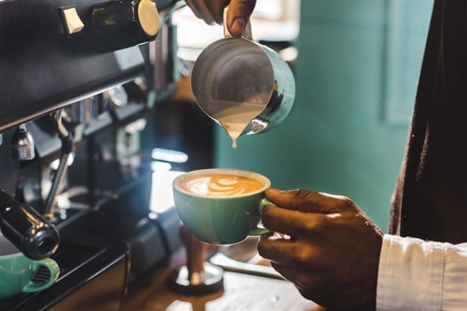 Close-up partial view of barista preparing cappuccino in coffee shop — Photo