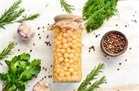 Pickled chickpeas in a glass jar. Turkish peas. Food stocks. Top view.