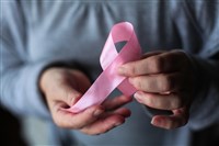 Cancer stocks to consider; image of someone holding a pink ribbon