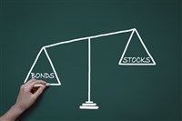 chalk drawing showing a scale with words stocks and bonds indicating balanced portfolio