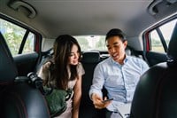 asian couple in back of car showing ride sharing