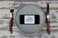 smartphone screen with logo of UNFI on plate with cutlery