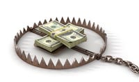 Photo showing a metal trap with stacks of money inside of it. Learn how to identify and avoid dividend traps to ensure healthy returns on your investment portfolio with our detailed guide.