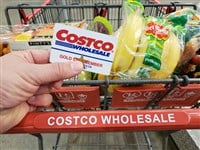 Photo of a Costco shopping card full of food and goods, and a person holding a Costoc membership card. Is it time for Costco to issue another stock split?
