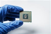 Close-up view on a new semiconductor microchip in gloved hand of computer scientist