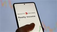 Realty Income logo and stock on smartphone screen