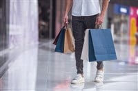 Cropped image of handsome guy with shopping bags doing shopping in the mall