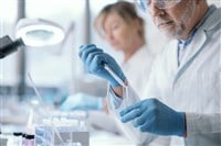 Professional medical researcher working in the laboratory, he is examining samples