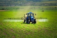 Farming tractor plowing and spraying on field