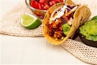 Mexican traditional authentic homemade tacos with pulled pork beef chili con carne serve with tomato salad and avocado guacamole and dip sauce