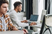 Selective focus of two multicultural programmers working together in office - stock image