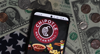 Chipotle Mexican Grill logo seen displayed on a smartphone with United States Dollar notes and coins in the background