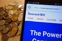 Tencent website displayed on smartphone and stack of coins - Stock Editorial Photography