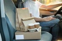 Blank box, coffee cups, paper packages and courier in car. Deliv — Photo