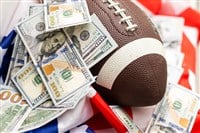 Money and football on american flag background, closeup. Concept of sports bet.