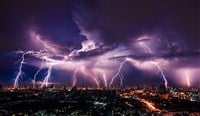 Lightning storm over city in purple light — Photo