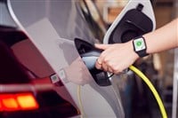 Close Up Of Hand Attaching Power Cable To Environmentally Friendly Zero Emission Electric Car - stock image