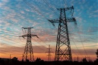 Electricity pylons and lines at dusk at sunset. - stock image