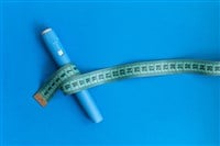 Blue injector dosing pen for subcutaneous injection of antidiabetic medication, anti-obesity medication on a blue background. Measuring tape around the injector. Drug and weight loss — Photo