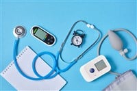 Digital blood pressure monitor, glucometer, stethoscope, notepad and alarm clock on blue background top view — Photo