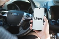 Wroclaw, Poland - AUG 25, 2020: Uber driver holding smartphone in car. Uber is sharing-economy service for ubran transport.