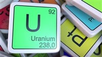 Uranium tag on the pile of periodic table of the chemical elements tags