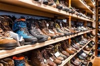 Many pairs of hiking, trekking and mountaineering boots for sale at travel shop — Photo