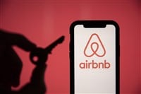 LONDON, UK - May 15 2020: Airbnb home rental logo on a phone with a key