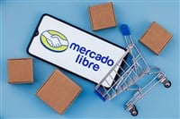 Photo of a smartphone with the MercadoLibre logo inside a small shopping cart surrounded by brown boxes; e-commerce