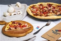 Photo of a Domino's pizza pie set on a table.