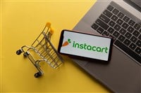 Photo of Instacart logo on iPhone display with a mini shopping cart