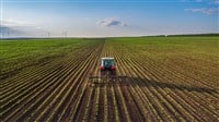 Photo of a tractor plowing a crop field.