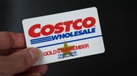 Costco Gold Star Membership card held against a black background. — Stock Editorial Photography